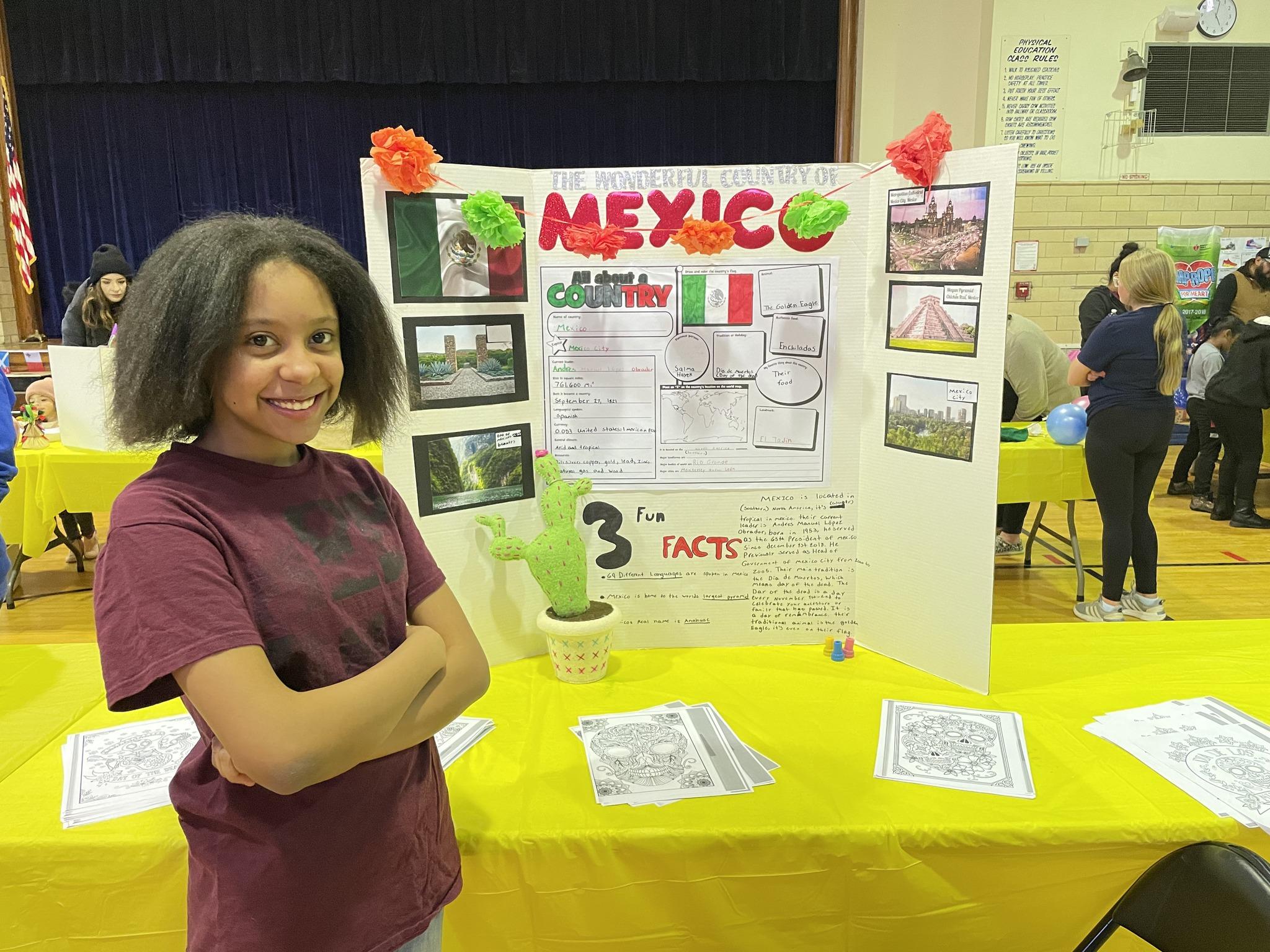 student standing in front of her Mexico cardboard